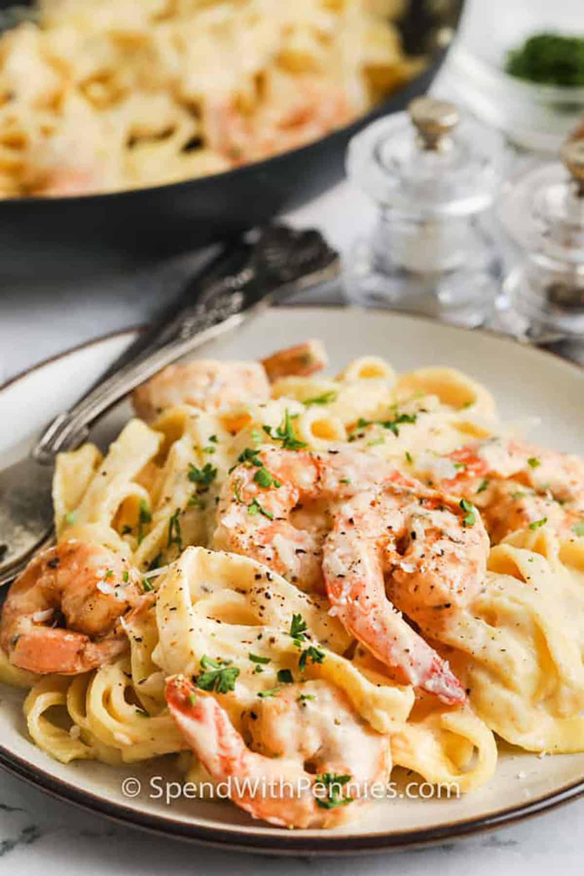 plated Shrimp Alfredo with pan full in the back