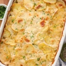 A 9x13 pan of baked scalloped potatoes topped with parsley