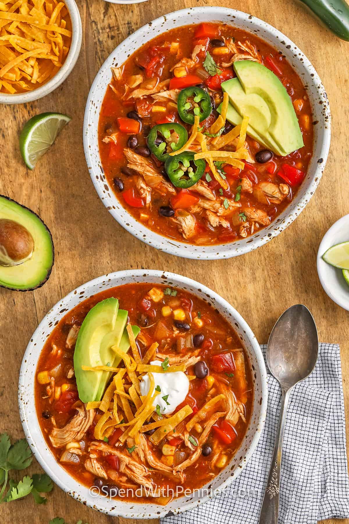 two bowls of chicken enchilada soup topped with avocado