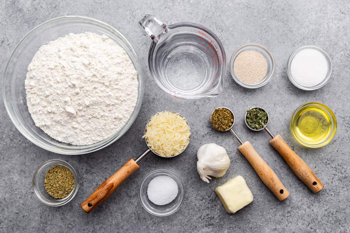 An overhead view of the ingredients needed to make garlic parmesan herb bread.