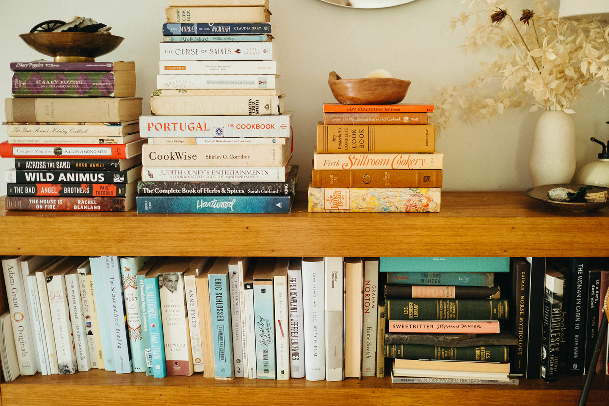 Open shelving displays a beautifully arranged assortment of cookbooks and novels