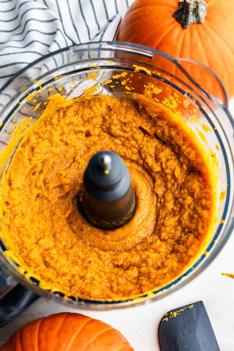 The bowl of a food processor full of pumpkin puree.