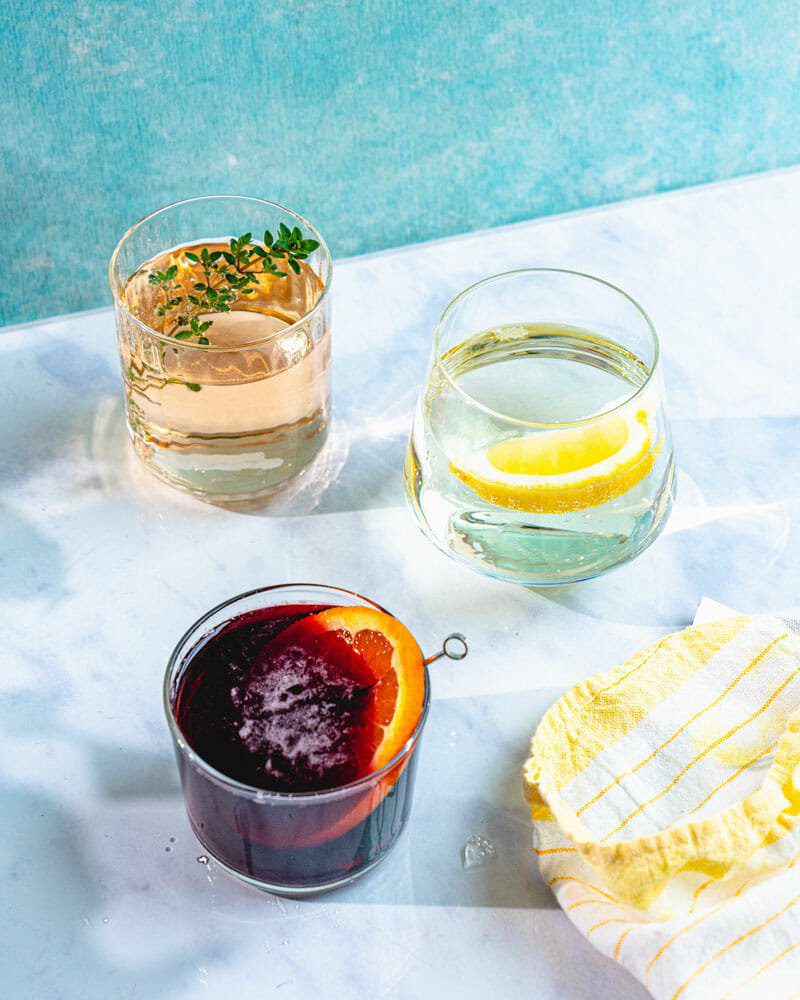 A white wine spritzer, rose spritzer, and red wine spritzer displayed on a tabletop