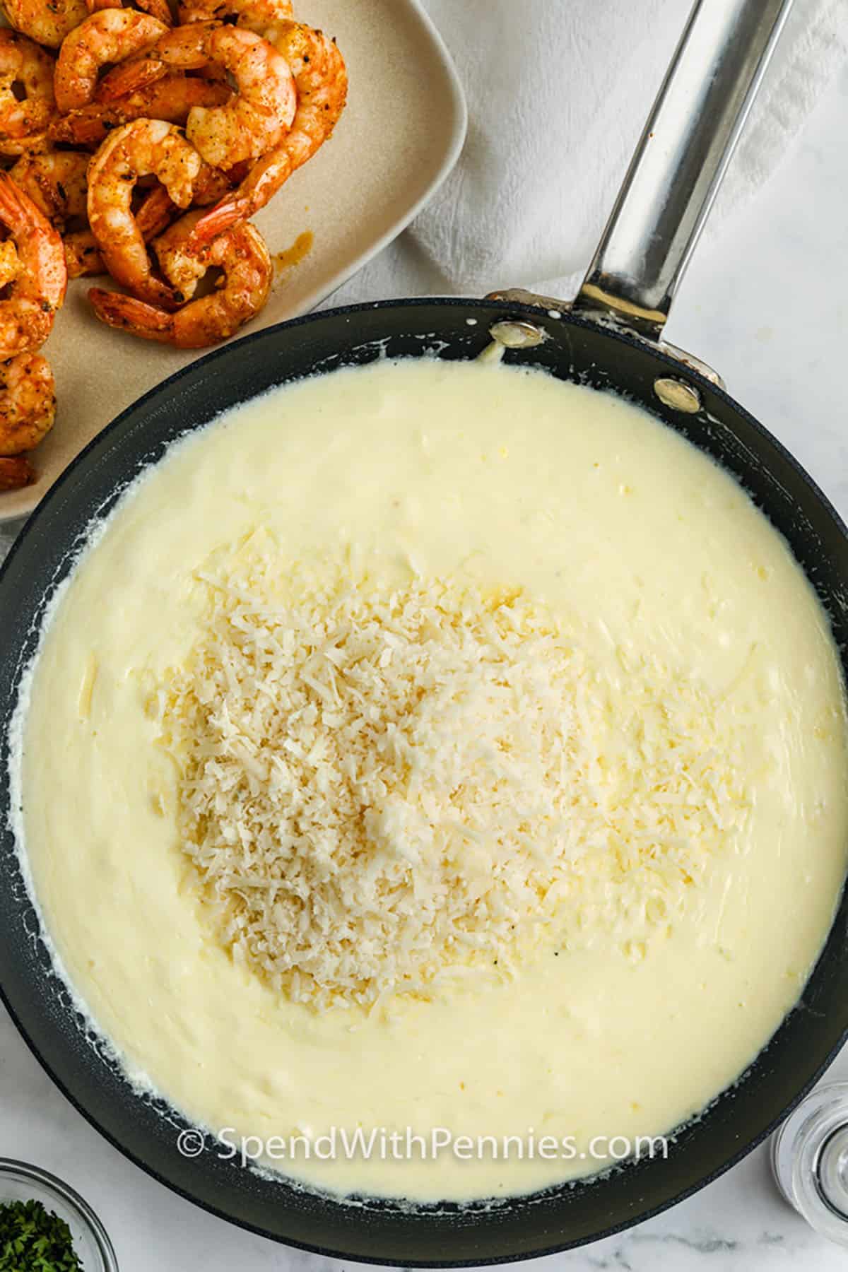 adding parmesan to pan to make sauce for Shrimp Alfredo