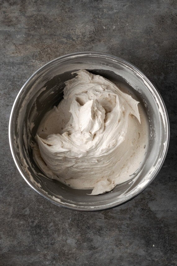 Cinnamon buttercream frosting in a metal mixing bowl.